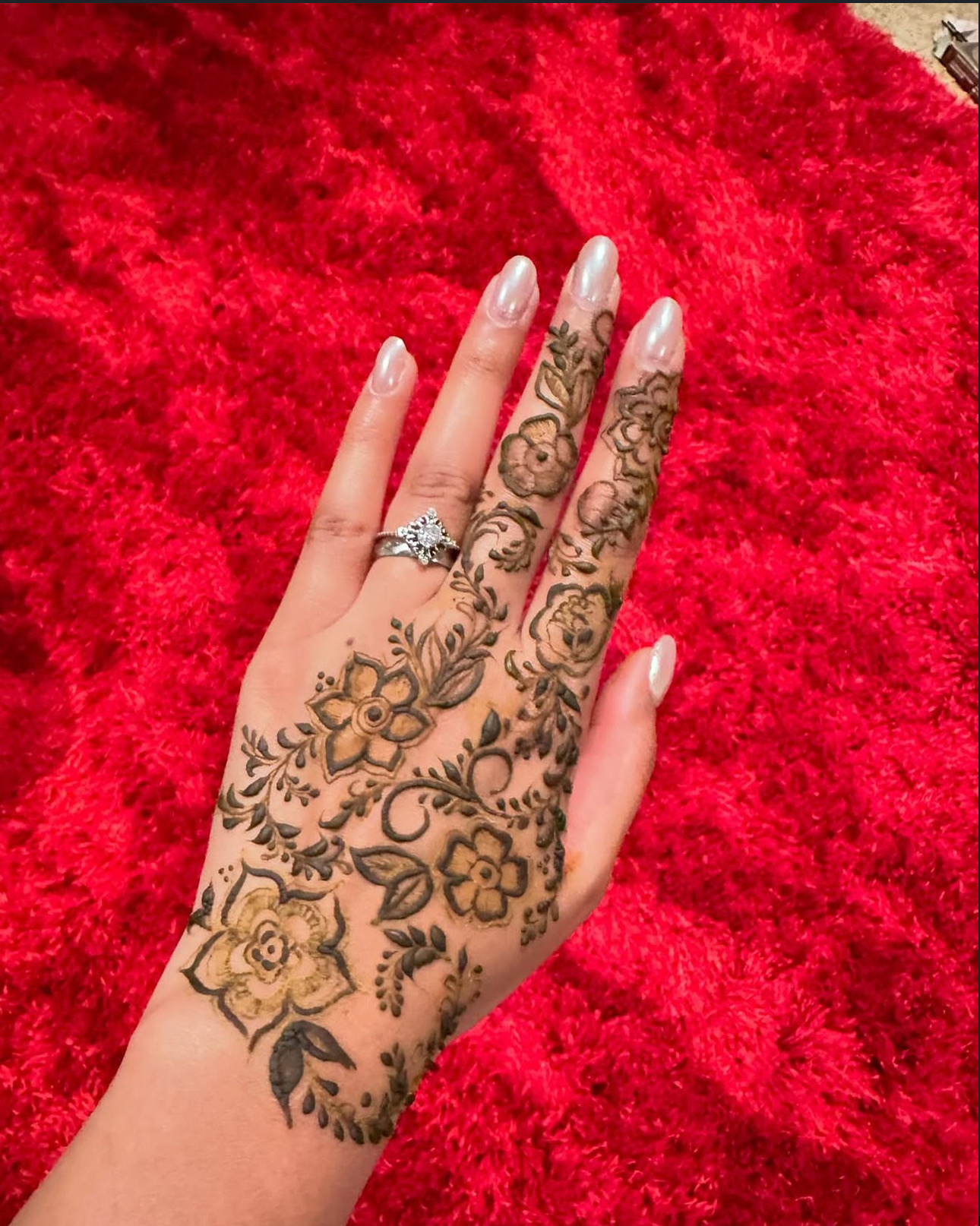 Henna floral hand design on red background Edmonton