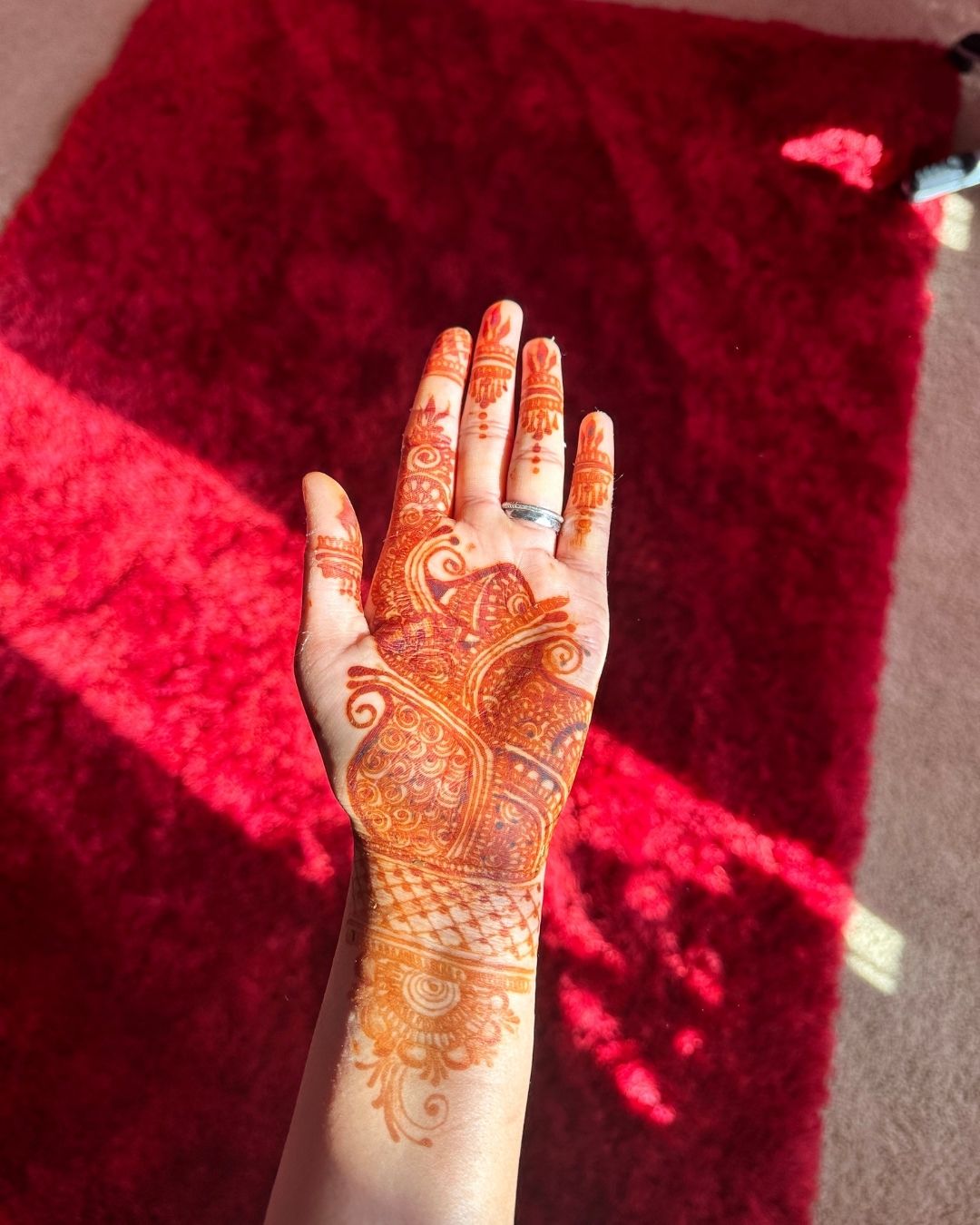 Deep henna stain palm on red carpet Edmonton mehndi